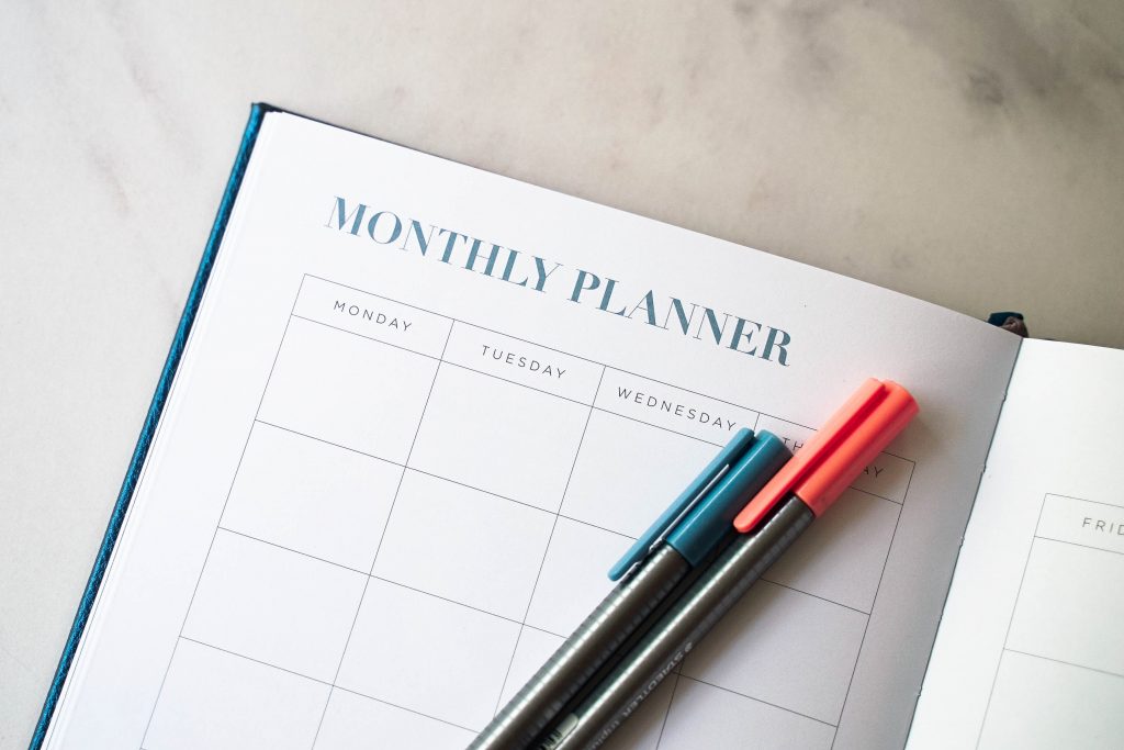 Monthly planner book open with pens