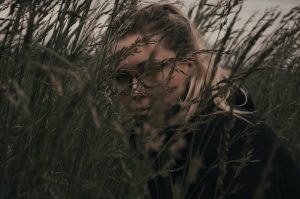 Woman's face obscured by long grass